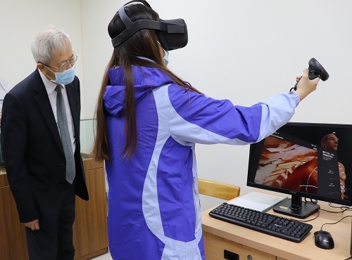 President Ming-Je Tang (left) listened to the operating instructions of the VR acupuncture teaching.